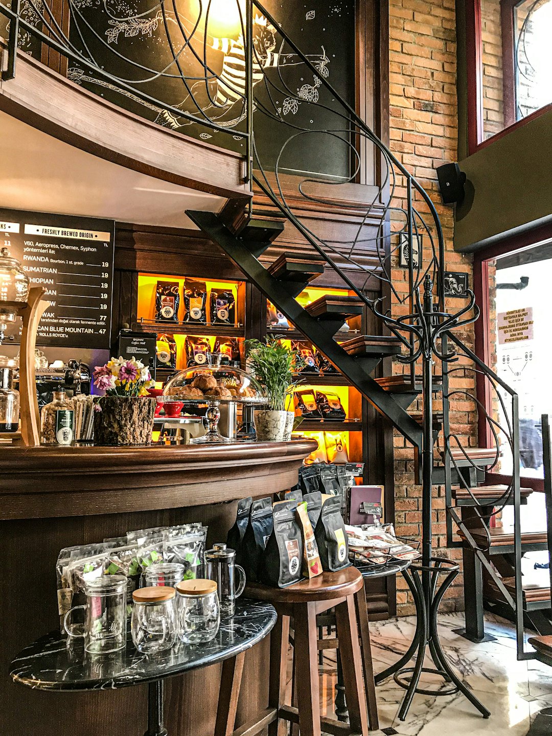 Bancone di una caffetteria con pasticcini vicino a una scala a chiocciola.